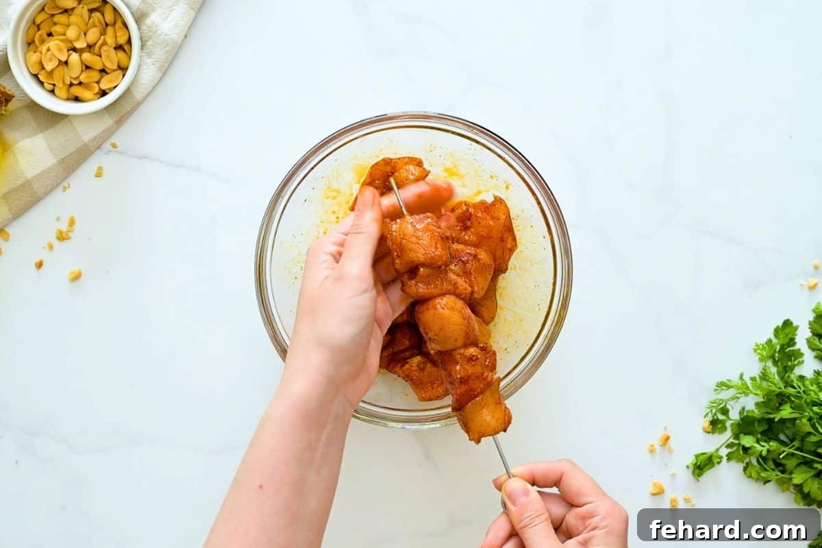 Sweet and Spicy Chicken Kabobs Threading cubes of spice rubbed chicken onto metal skewers.