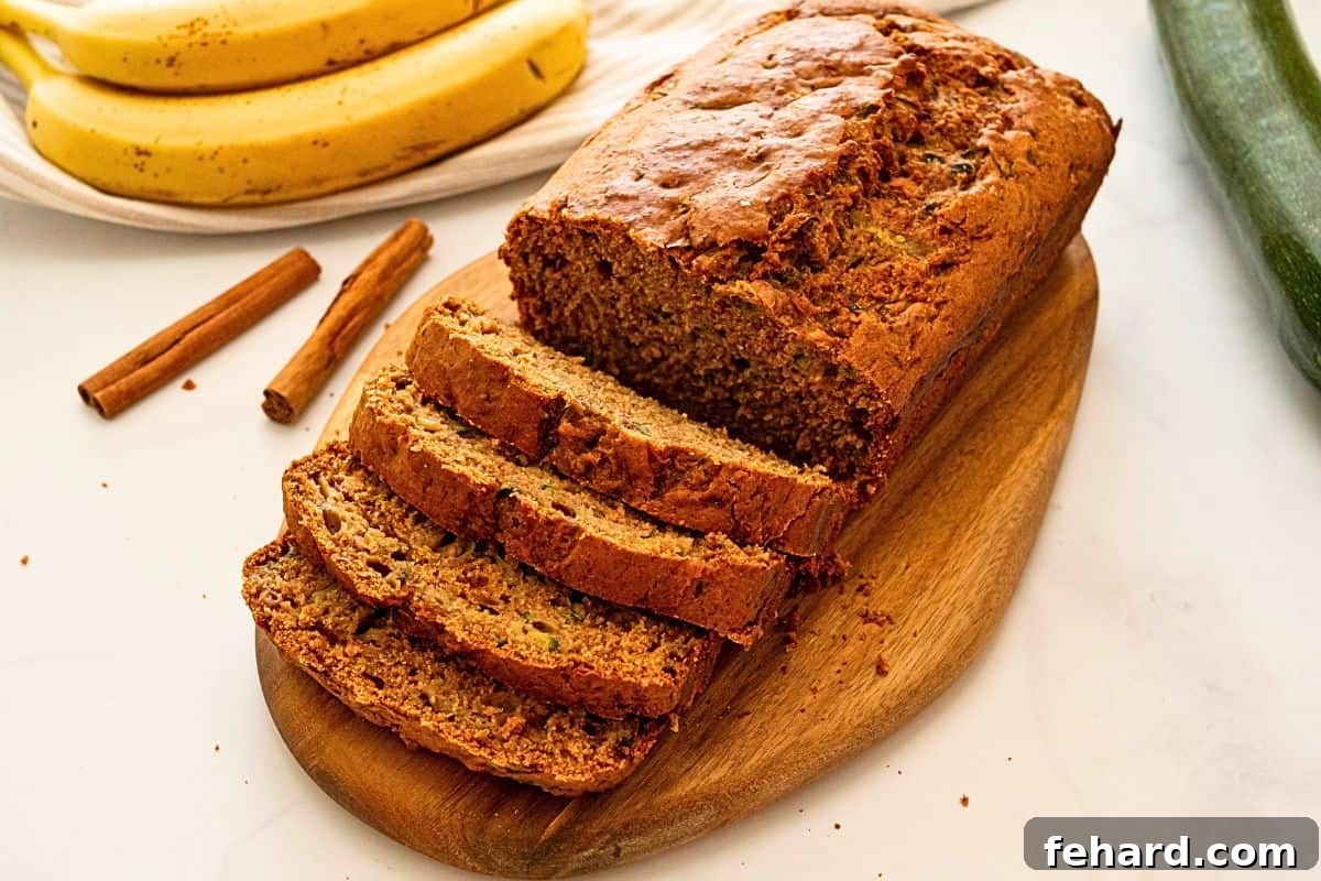 Zucchini and Banana Bread Sliced loaf of whole wheat zucchini bread made with mashed banana on cutting board.