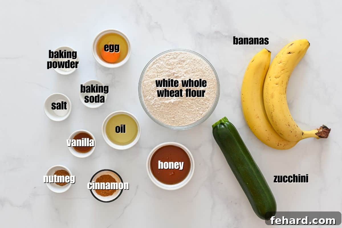 Recipe for Zucchini Banana Bread 2 ripe bananas, 1 small zucchini, whole wheat flour, honey, oil, egg, and spices laid out on counter.
