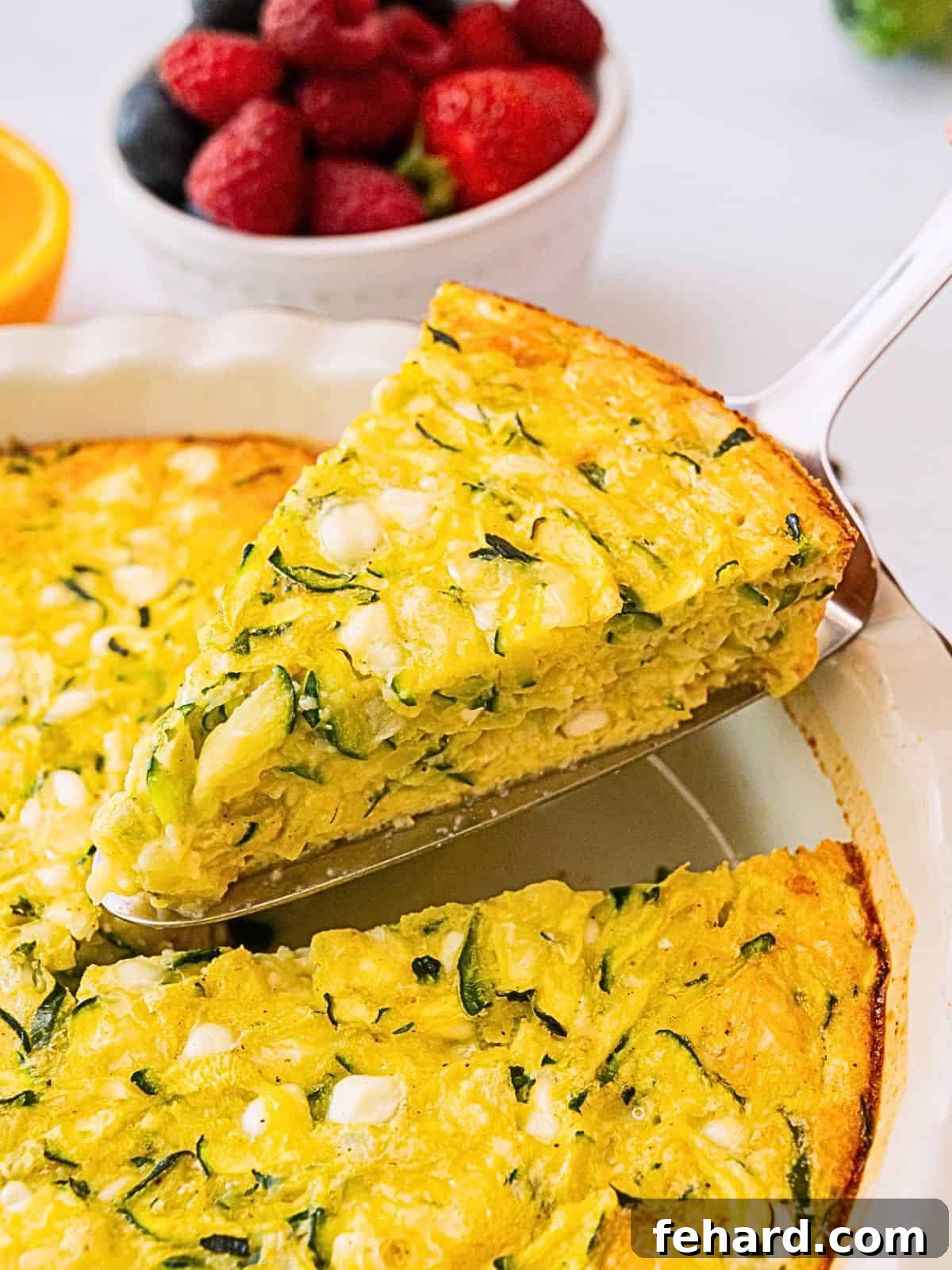 Crustless Zucchini Pie Recipe Spatula pulling out slice of crustless zucchini pie from pie plate.
