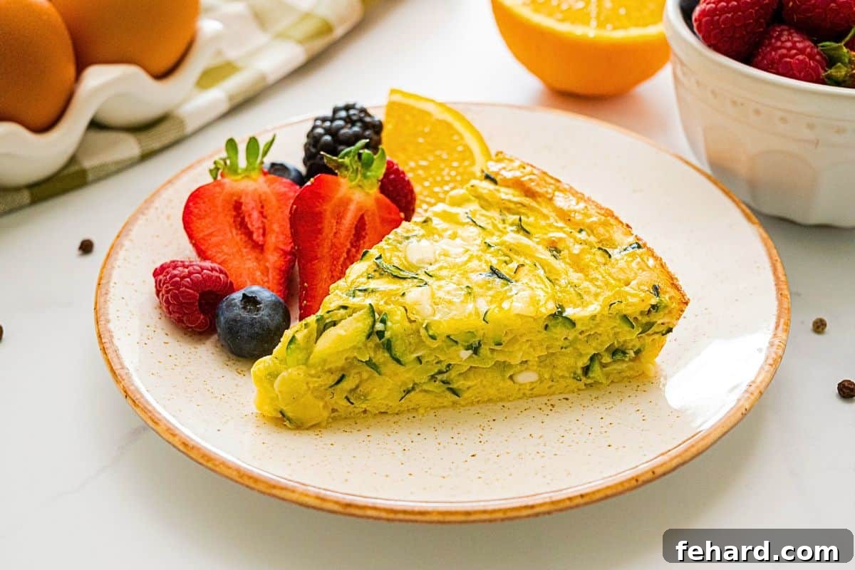 Zucchini Egg Pie Slice of crustless zucchini pie showing shredded zucchini and cottage cheese in pie next to fresh fruit.