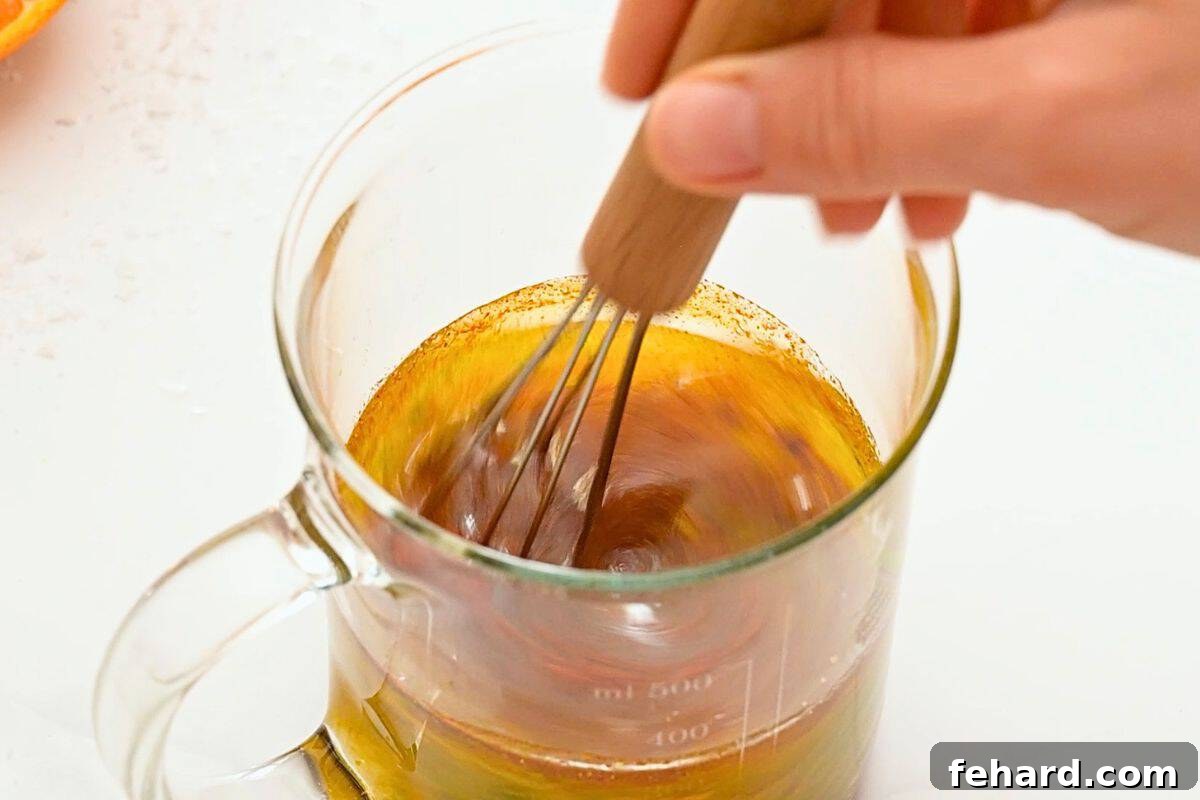 Orange juice, lime juice, garlic, paprika, and oil mixed together in small glass measuring cup.