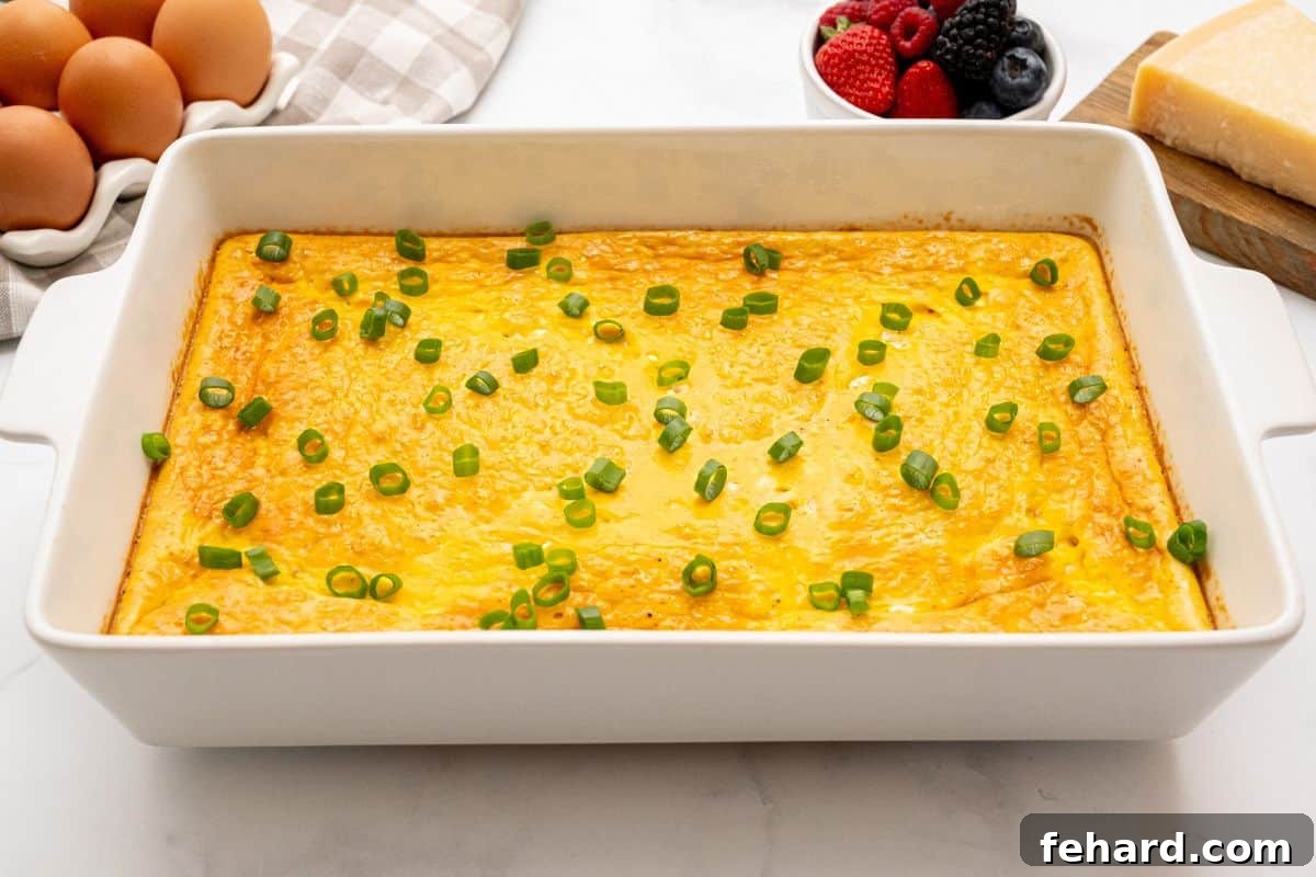 Egg Bake with Cottage Cheese Baked Eggs with cottage cheese in white baking dish topped with sliced green onions.