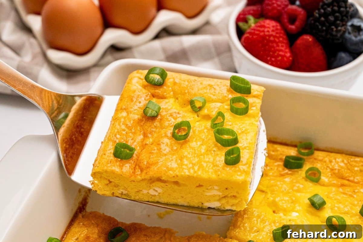 Easy Egg and Cottage Cheese Bake Slice of baked cottage cheese egg being lifted by spatula from casserole dish showing fluffy eggs with a few small curds of cottage cheese.