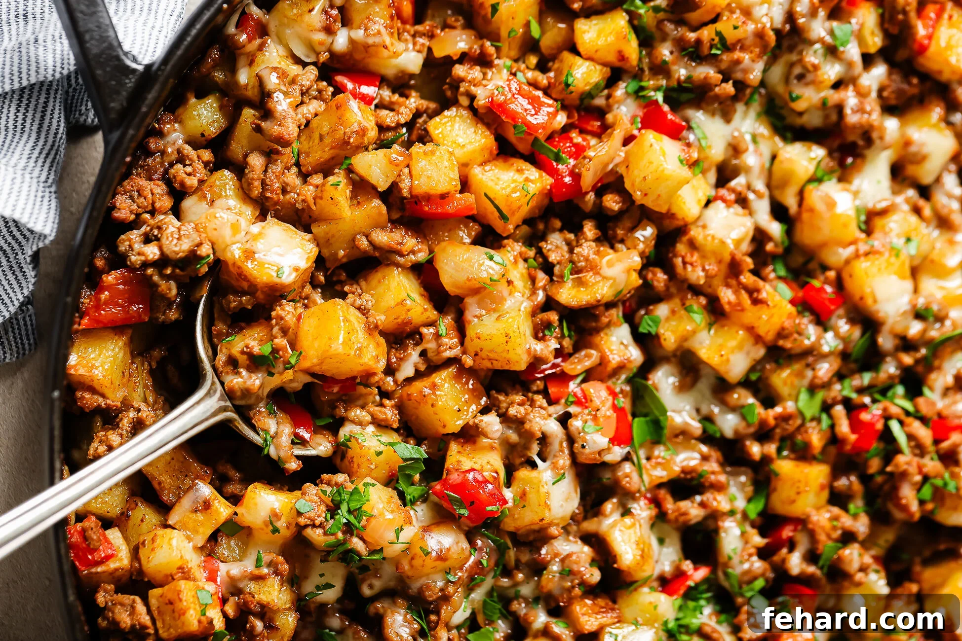 Close-up of ground beef and potatoes in a cast-iron skillet.