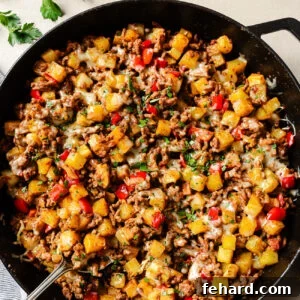 Overhead view of ground beef and potatoes cooked in a cast-iron skillet.