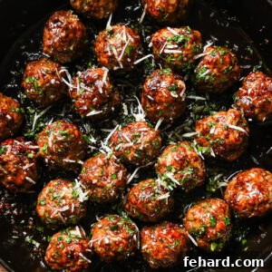 A pan filled with Honey Garlic Meatballs, glazed to perfection and garnished with chopped herbs and grated cheese.